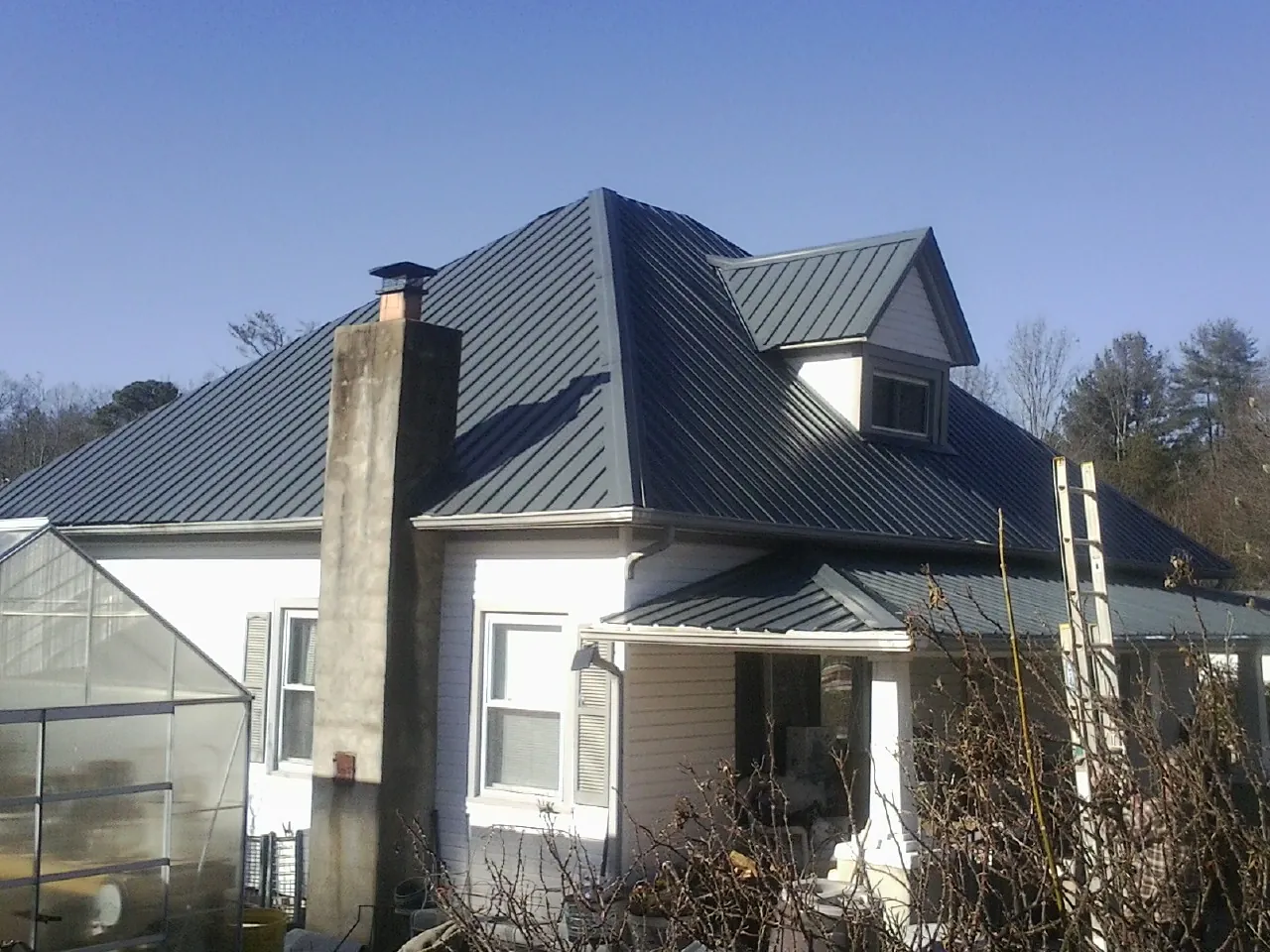 Dark blue standing seam metal roof on a white farmhouse with dormer — Slate & Tile Roof Repair by Roofing Brothers in Tualatin