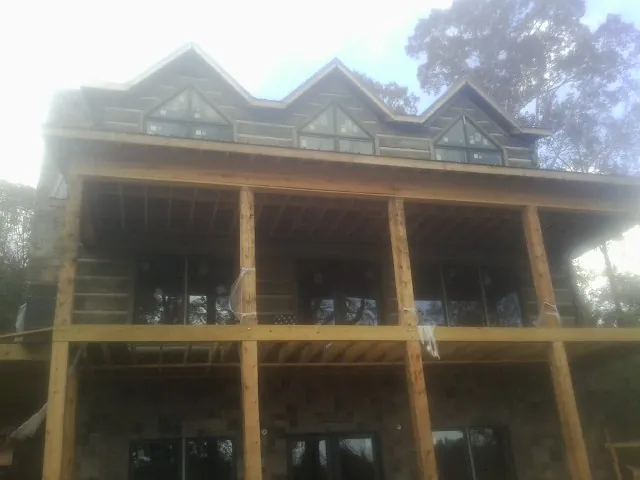 Dormers and porch framing on a large log home under construction — Roof Coating work by our crew in Tualatin