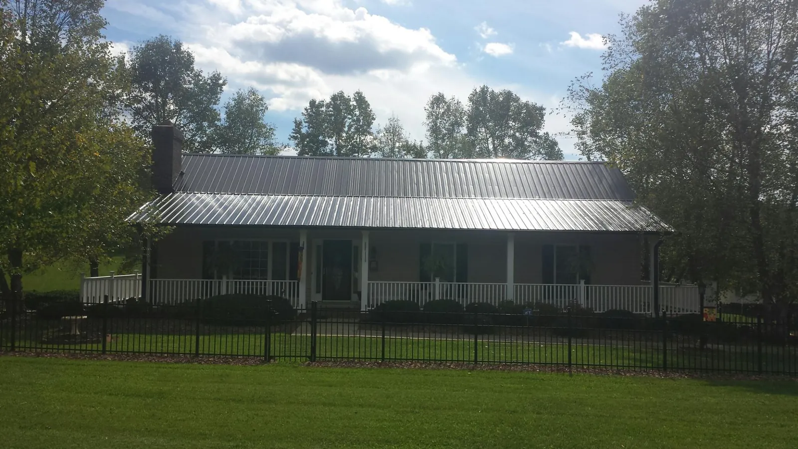 Gray metal roof on a brick ranch with a full width front porch — Gutter Guard Installation work by our crew in Tualatin